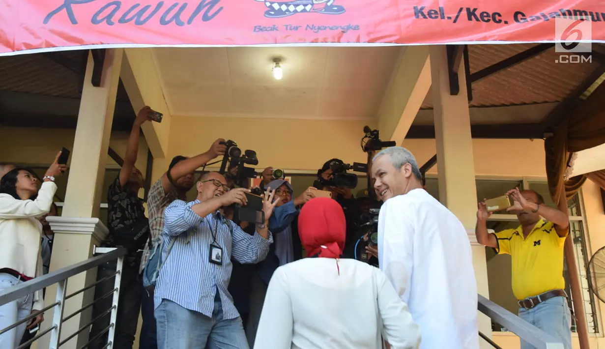 Calon Gubernur Jawa Tengah nomor urut 1, Ganjar Pranowo bersama istri, Siti Atiqoh tiba di TPS 02 Kelurahan Gajahmungkur, Kota Semarang, Rabu (27/6). Ganjar Pranowo bersama istri menyalurkan hak pilihnya di Pilkada Jawa Tengah. (Liputan6.com/Gholib)