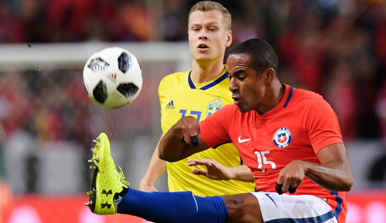 Bek Chile, Jean Beausejour berusaha membuang bola dari kawalan gelandang Swedia, Viktor Claesson saat bertanding pada pertandingan persahabatan internasional Friends di Arena, Stockholm, (24/3). Chile menang 2-1 atas Swedia. (Anders Wiklund/TT via AP)