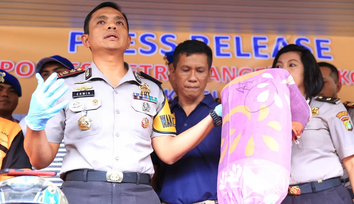 Wakapolres Tangerang Kota, AKBP Erwin Kurniawan menunjukkan guling yang digunakan pelaku untuk membekap mulut korban. Di guling itu juga ada bercak darah korban. (Adrian Putra/Bintang.com)