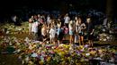 Orang-orang berkumpul di depan karangan bunga untuk Ratu Elizabeth II di Green Park, dekat Istana Buckingham di London, Senin (12/9/2022). Elizabeth juga sempat bertugas selama Perang Dunia II sebagai mekanik selagi menjabat sebagai kepala negara. (AP Photo/Markus Schreiber)