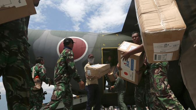Personil militer Jepang dibantu TNI mengangkut bantuan logistik dari pesawat kargo AU Jepang di bandara Mutiara Sis Al-Jufri, Palu, Sulteng (6/10). Gempa berkekuatan 7,5 mengguncang kota Palu pada 28 September. (AP Photo/Tatan Syuflana)