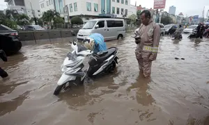 Seorang pengendara memperbaiki motornya yang mogok saat melintasi banjir di Jalan Boulevard Barat Raya, Kelapa Gading, Jakarta, Kamis (15/2). Hujan lebat yang mengguyur Jakarta mengakibatkan sejumlah wilayah terendam banjir. (Liputan6.com/Arya Manggala)