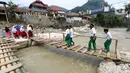 Siswa melintasi jembatan darurat berbahan bambu di Kampung Ciasahan, Desa Sukamaju, Kabupaten Bogor, Kamis (6/2/2020). Pembangunan kembali jembatan Ciasahan yang ambruk akibat banjir bandang pada Rabu (1/1) itu diharapkan mampu memulihkan aktivitas dan perekonomian warga. (merdeka.com/Arie Basuki)