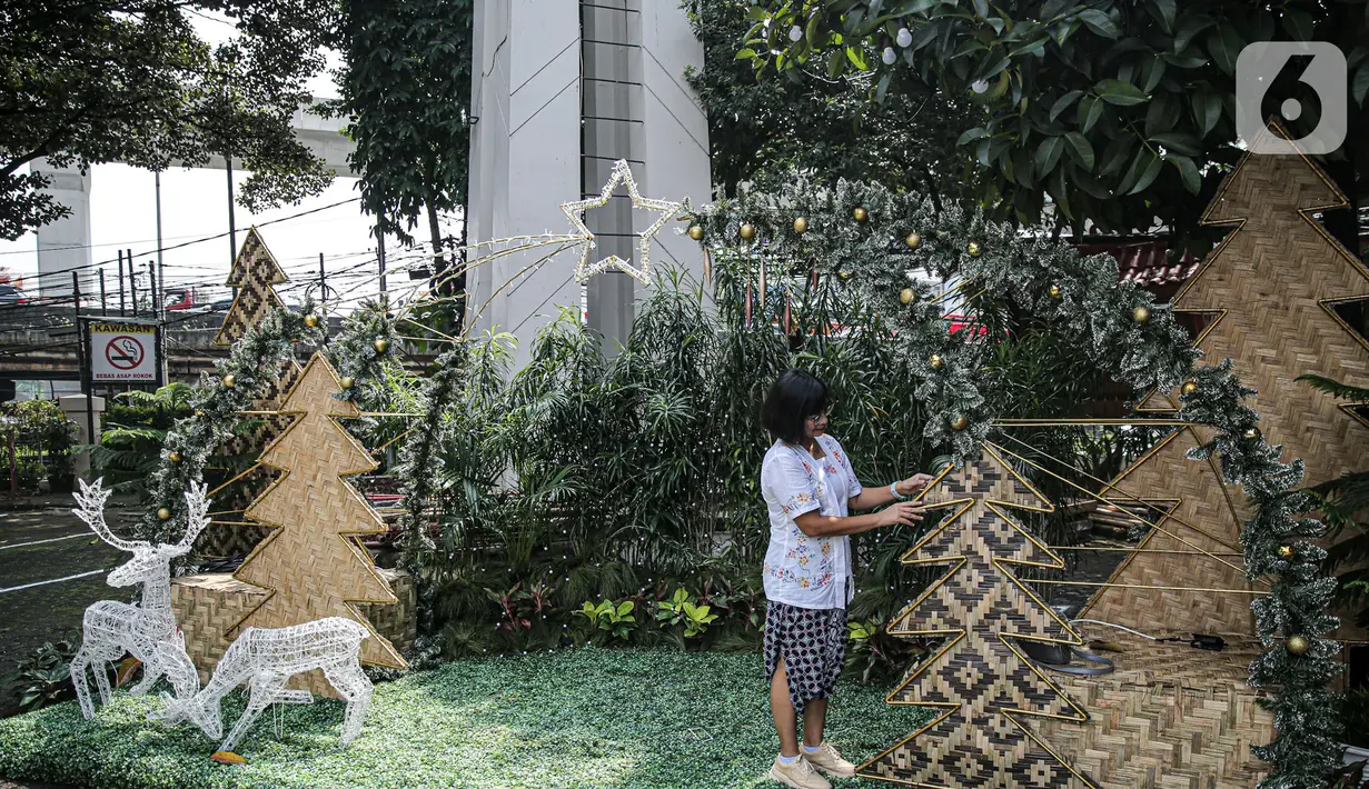 Umat nasrani mendekorasi Natal di Gereja Katolik Santo Stefanus, Jakarta, Selasa (20/12/2022). Pada perayaan Natal 2022 dengan mengusung tema “Green Christmas” mereka membuat pohon Natal dari gedek, tampah, besek sedangkan ornamen goa Natal menggunakan barang bekas pakai karton telur, selongsong tissue gulung, serta buku misa paskah 2019. (Liputan6.com/Faizal Fanani)