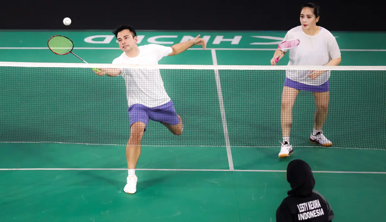 Pasangan selebritas Raffi Ahmad dan Nagita Slavina berusaha mengembalikan kok saat bertanding melawan pasangan Rizky Billar dan Lesti Kejora pada laga bulu tangkis ganda campuran Turnamen Olahraga Selebriti Indonesia (TOSI) di GOR UNJ, Jakarta, Minggu (16/07/2023). Raffi dan Gigi kalah dua set langsung dari Rizky Billar dan Lesti dengan skor 12-21, 10-21.(Bola.com/Bagaskara Lazuardi)