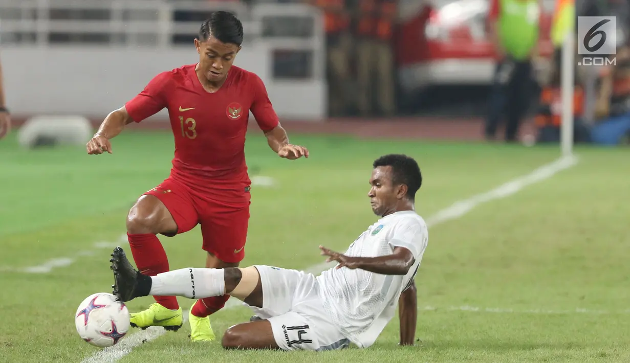 Pemain sayap Timnas Indonesia, Febri Hariyadi (kiri) menghindari tekel pemain Timor Leste, Adelino Trindade Coelho pada penyisihan grup B Piala AFF 2018 di Stadion GBK, Jakarta, Selasa (13/11). Indonesia unggul 3-1. (Liputan6.com/Helmi Fithriansyah)