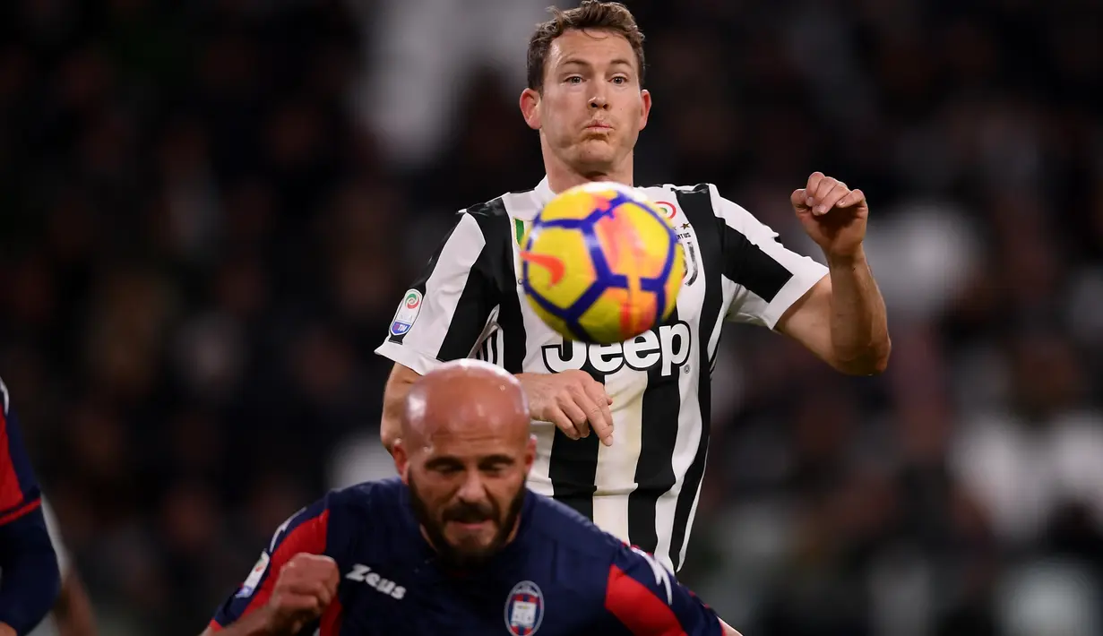 Pemain Juventus, Stephan Lichtsteiner (atas) berebut bola dengan pemain Crotone, Arlind Ajeti pada lanjutan Premier League di Allianz Stadium, Turin, Italy, (26/11/2017). Juventus menang 3-1. (AFP/Marco Bertorello)