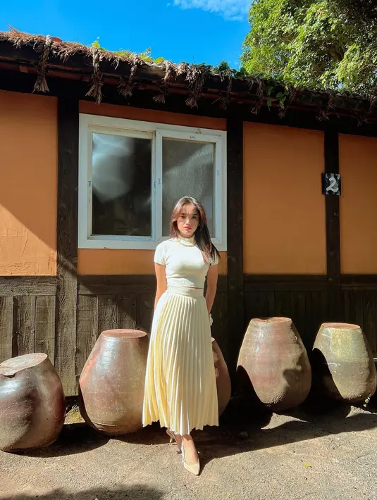 Kali ini, Fuji memperlihatkan sisinya yang anggun mengenakan turtleneck top dan rok pleats serba warna broken white. Untuk alas kaki, Fuji memilih pointed heels warna senada. Gelang bunga pun mempermanis penampilannya. [fuji_an]