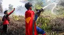 Pelajar bernama Rudiansyah dengan mengenakan kostum Superman membantu memadamkan kebakaran hutan dan lahan di Petuk Katimpun, Palangkaraya, Kalimantan Tengah, 17 Agustus 2026. (AFP/ Reina)
