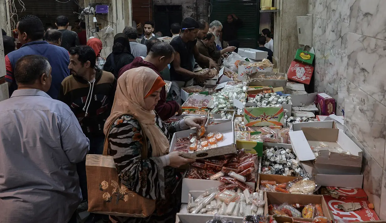 Warga Mesir membeli permen gula tradisional di sebuah toko ibu kota Kairo, Senin (19/11). Permen tradisional yang dibuat dalam berbagai bentuk boneka itu merupakan salah satu sajian rutin warga Mesir dalam perayaan Maulid Nabi. (Mohamed el-Shahed/AFP)