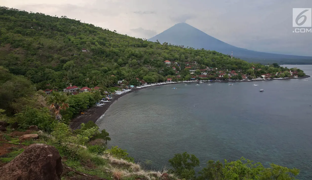 Lanskap Gunung Agung terlihat dari kawasan Pantai Amed, Karangasem, Bali, Rabu (6/12). Kawasan Amed menjadi salah satu lokasi favorit bagi wisatawan untuk menikmati matahari terbenam serta lansekap Gunung Agung. (Liputan6.com/Immanuel Antonius)