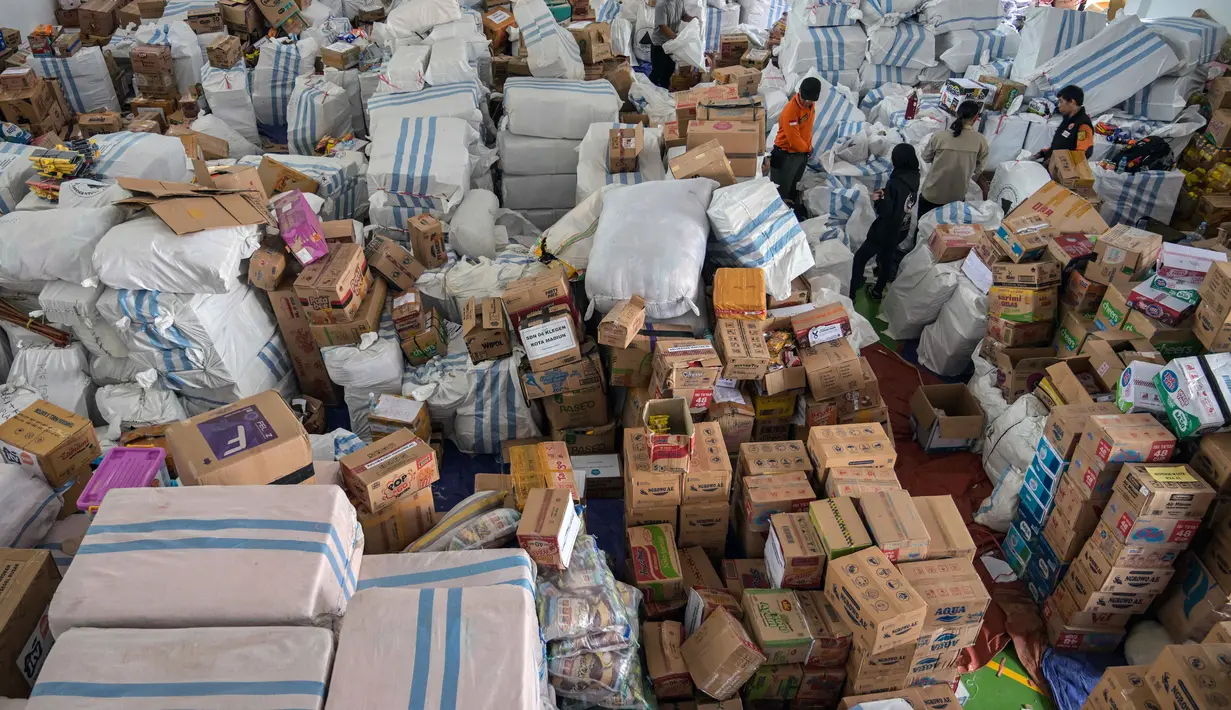 Kepala Bidang Kedaruratan dan Logistik BPBD Jatim, Satria Nurseno, mengatakan pengiriman logistik itu merupakan hasil penggalangan dari Pemprov Jatim, Pemerintah Kabupaten/Kota, organisasi masyarakat, hingga kontribusi dari dunia usaha. Tampak dalam foto, para relawan mengemasi perlengkapan untuk dikirimkan ke daerah-daerah terdampak banjir di Badan Penanggulangan Bencana Daerah (BPBD) Sidoarjo, Provinsi Jawa Timur, pada Jumat 5 Desember 2025. (JUNI KRISWANTO/AFP)