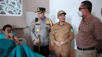 Kepala Polres Bengkalis AKBP Indra Wijatmiko menjenguk penderita tumor kulit di rumah sakit. (Liputan6.com/M Syukur)