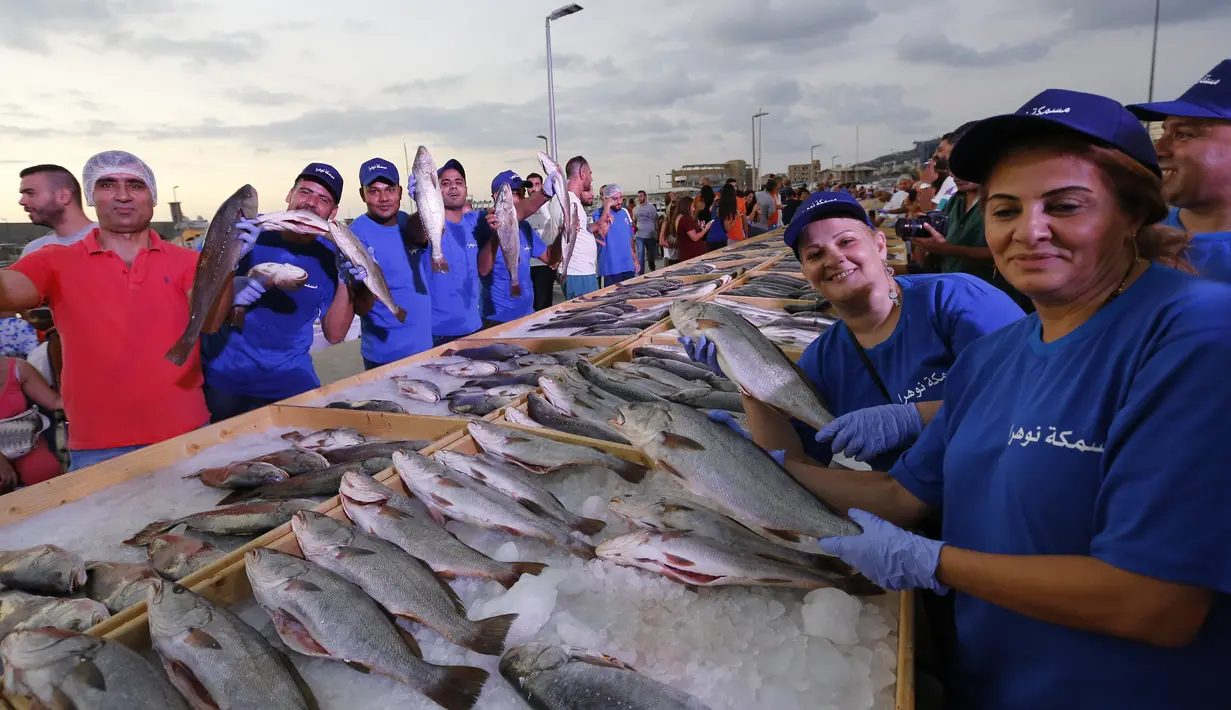 Anggota dari Lebanon's Batroun Traders Association memegang ikan yang berhasil memecahkan rekor makanan laut terbanyak di daerah kota pantai Batroun, Minggu (4/9). Menurut panitia, total ikan yang dikumpulnya sebanyak 2 ton 614 kg. (AFP PHOTO/Anwar AMRO)