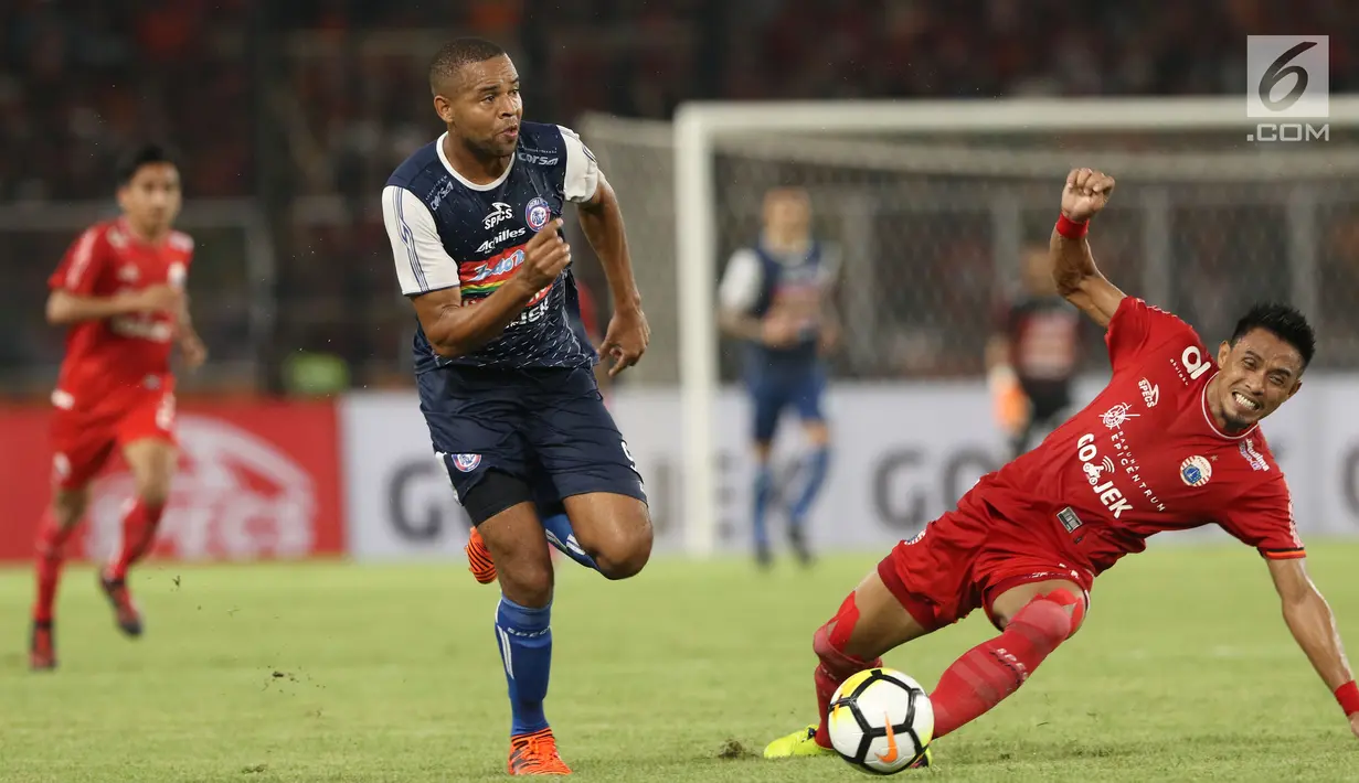 Penyerang Arema FC, Thiago Futuoso (kiri) melewati hadangan bek Persija, Maman Abdurrahman pada babak pertama lanjutan Liga 1 Indonesia 2018 di Stadion GBK, Jakarta, Sabtu (31/3). (Liputan6.com/Helmi Fithriansyah)