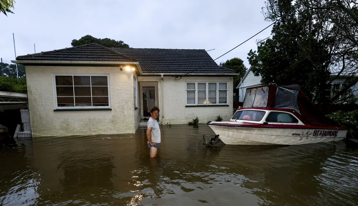 Slavko Snjegota berdiri di air setinggi lutut di luar rumahnya di Auckland, Selandia Baru, Rabu (1/2/2023). Peringatan hujan lebat untuk Auckland dicabut, meskipun keadaan darurat tetap berlaku untuk kota terbesar di negara itu setelah curah hujan dan banjir yang mencapai rekor. pada hari Jumat menewaskan empat orang dan menyebabkan gangguan yang meluas. (Brett Phibbs/New Zealand Herald via AP)