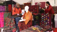 Pengunjung melihat-lihat produk kain tenun yang dipamerkan di Festival Sarung Indonesia 2019, Plaza Tenggara Kompleks GBK, Jakarta, Minggu (3/3). Festival ini diikuti sejumlah perajin sarung tenun dari berbagai daerah. (Liputan6.com/Helmi Fithriansyah)