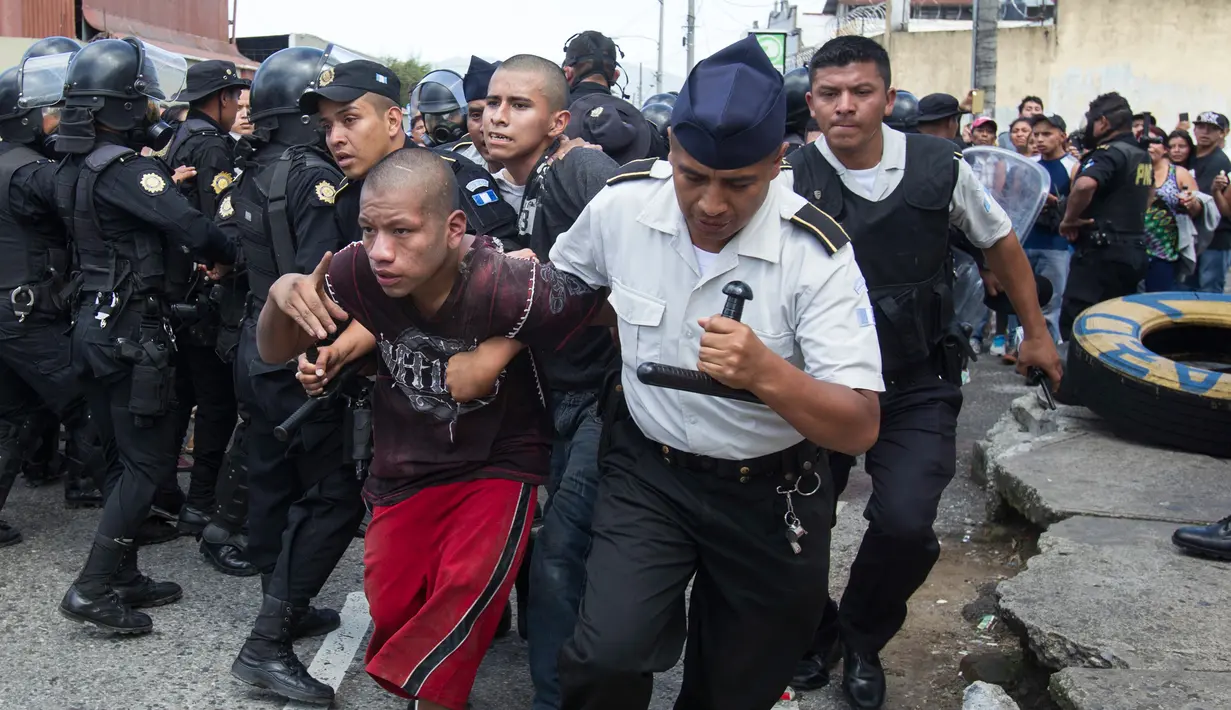 Petugas polisi membawa narapidana yang ditangkap dari penjara Juvenile Gaviotas di Guatemala City, Guatemala (3/7). Kerusuhan di penjara tersebut terjadi usai dua narapidana ditemukan tewas tergantung. (AP Photo / Moises Castillo)