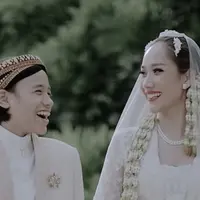 Noah terlihat mengenakan beskap coklat beige lengkap dengan bros keemasan dan inner putihnya. Dipadukan kain lilit batik coklatnya. [@itsmebcl]