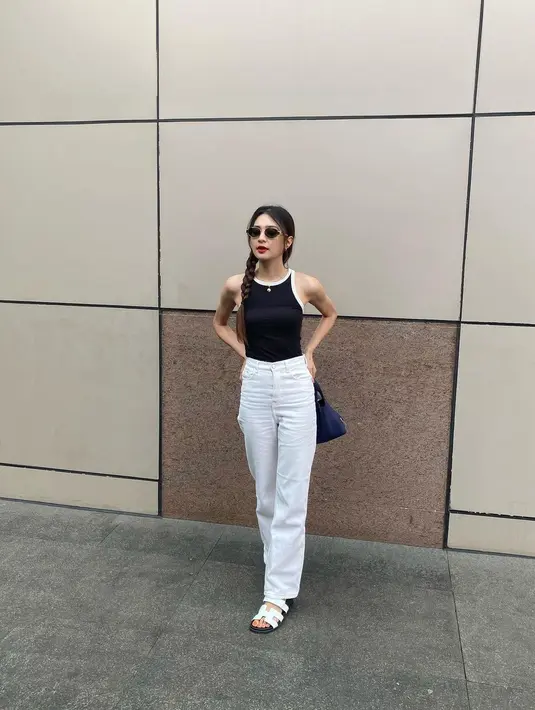 Penampilan kasual lainnya dari Mikha Tambayong. Ia mengenakan tank top hitam, dipadunya dengan celana jeans putih, dan sunglasses. [Foto: Instagram/miktambayong]