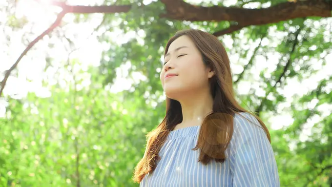 perempuan menghirup udara pagi