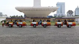 Wisatawan menaiki kereta wisata di kawasan Monumen Nasional (Monas), Jakarta, Sabtu (19/5). Kawasan wisata yang menjadi simbol ibukota tersebut menjadi salah satu lokasi warga untuk menunggu waktu berbuka puasa. (Liputan6.com/Immanuel Antonius)