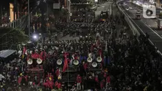 Mahasiswa dan elemen buruh bertahan hingga malam saat aksi di depan Gedung DPR/MPR/DPD, Jakarta, Kamis (16/7/2020). Dalam aksinya, mereka menolak pengesahan RUU Cipta Kerja atau Omnibus Law yang saat ini sedang dibahas DPR bersama pemerintah. (Liputan6.com/Johan Tallo)