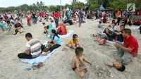 Sejumlah pengunjung bermain pasir di Pantai Ancol, Jakarta, Senin (26/6). Memasuki hari kedua lebaran Warga memanfaatkan liburnya bersama keluarga bertamasya ke tempat-tempat wisata yang ada di Jakarta kususnya Ancol. (Liputan6.com/Johan Tallo)