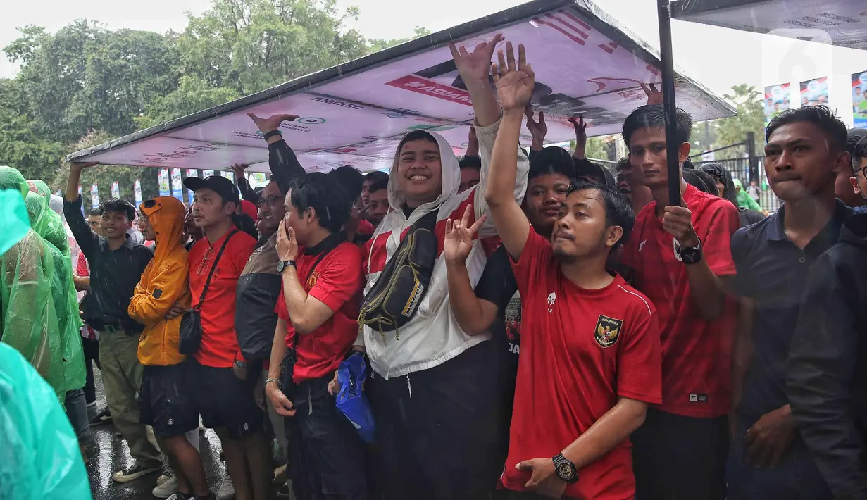 Guyuran hujan tidak mengurangi animo suporter timnas Indonesia untuk menonton pertandingan melalui layar lebar secara bersama-sama. (Liputan6.com/Angga Yuniar)