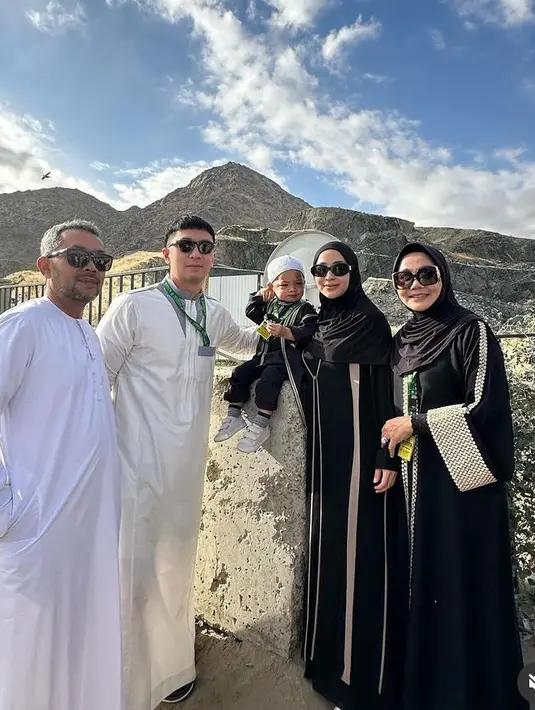 Ibu satu anak ini tampil mengenakan gamis hitam dengan salur coklat di bagian depan. Dipadukan kerudung warna serasi.  [@yorafebrina]