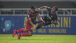 Pemain Martapura Dewa United, Selamet Budiono (kanan) terlibat benturan dengan pemain Persis Solo, Chrystna Bhagascara dalam laga semifinal Liga 2 2021 di Stadion Pakansari, Bogor, Senin (27/12/2021). (Bola.com/Bagaskara Lazuardi)