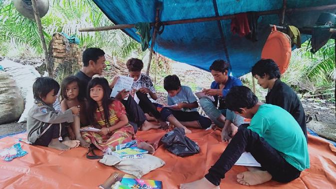 Sejumlah anak-anak rimba belajar bersama Gentar di wilayah Makekal Ilir, Kabupaten Tebo, Jambi, Kamis (19/11/2020). Gentar menjadi salah satu kader pendidikan atau guru alternatif bagi anak-anak rimba di kelompoknya. (Liputan6.com/Gresi Plasmanto)