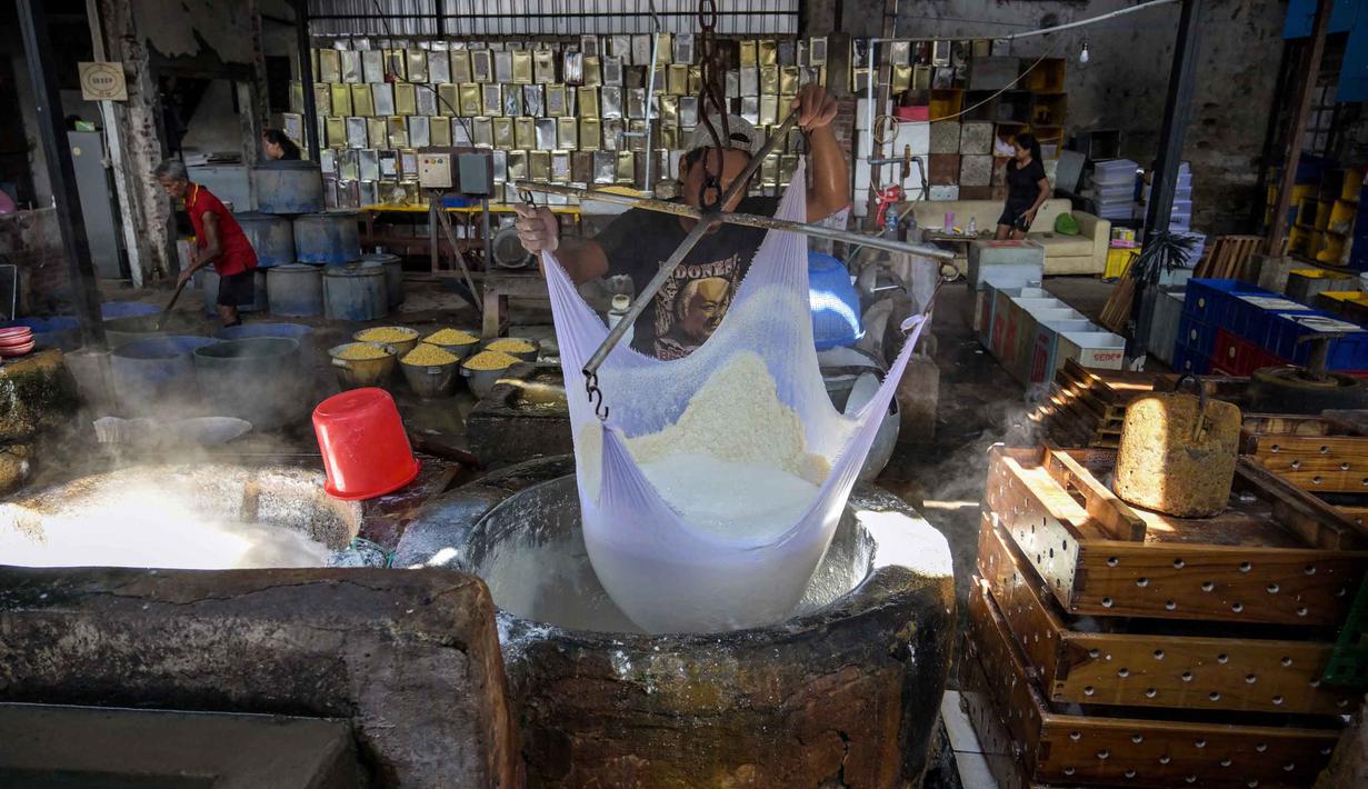 Seorang pekerja menyaring kedelai giling yang sudah dimasak untuk mendapatkan ekstraknya di sebuah pabrik tahu, Surabaya, Jawa Timur pada Kamis 5 Februari 2026. Lonjakan kenaikan harga kedelai mulai dirasakan sejumlah pelaku usaha tahu di sejumlah wilayah di Jawa Timur, di antaranya di Jombang, Bondowoso, dan Jember. (JUNI KRISWANTO/AFP)