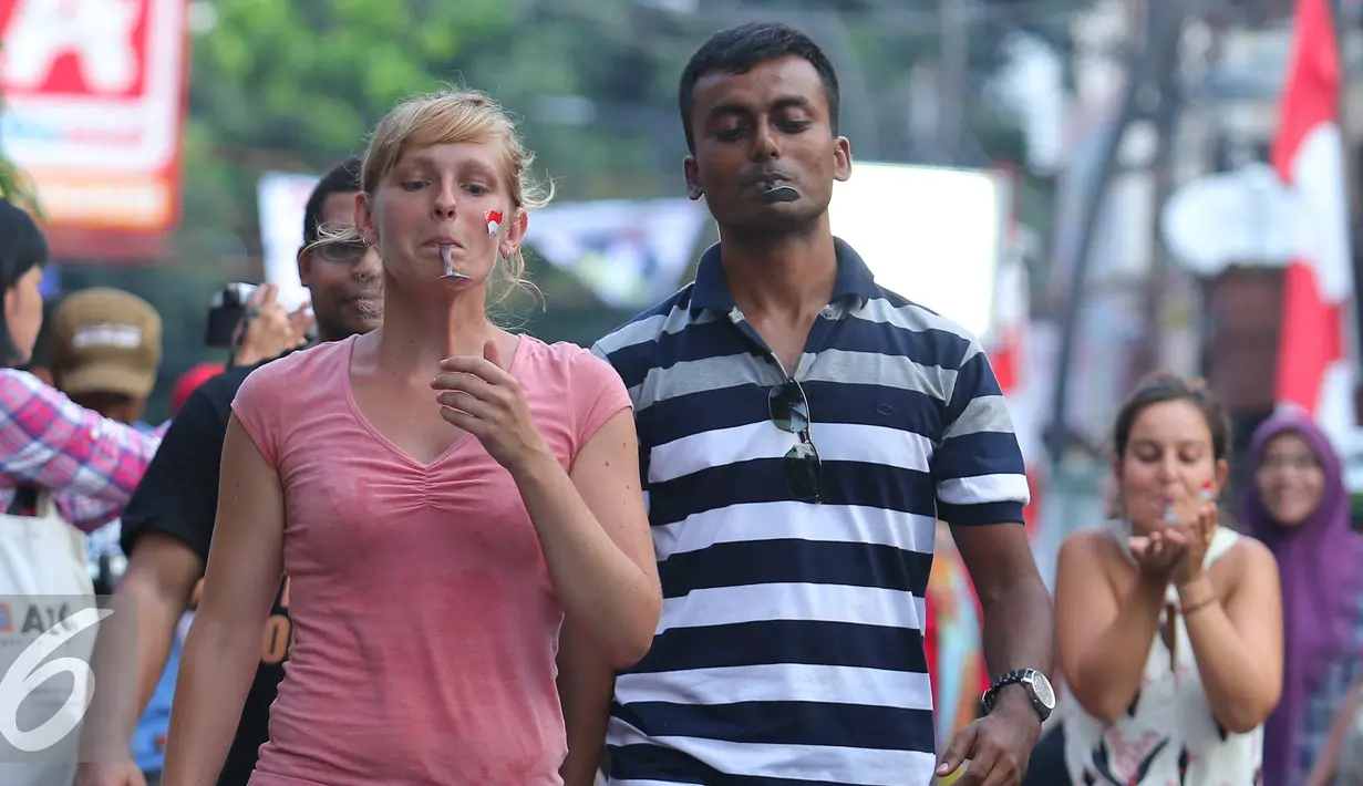 Sejumlah WNA mengikuti lomba membawa kelereng dengan sendok di Jalan Jaksa, Jakarta, Rabu (17/8). Perlombaan ini digelar dalam rangka memperingati HUT RI ke-71. (Liputan6.com/Angga Yuniar)