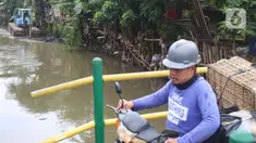 Warga melintas saat alat berat dioperasikan untuk pengerukan di Kali Mampang, Pondok Jaya, Sabtu (19/2/2022). Pengadilan Tata Usaha Negara (PTUN) Jakarta mengabulkan gugatan warga pada 19-21 Februari 2021 terkait program pencegahan banjir yang dilakukan Pemprov DKI. (Liputan6.com/Herman Zakharia)