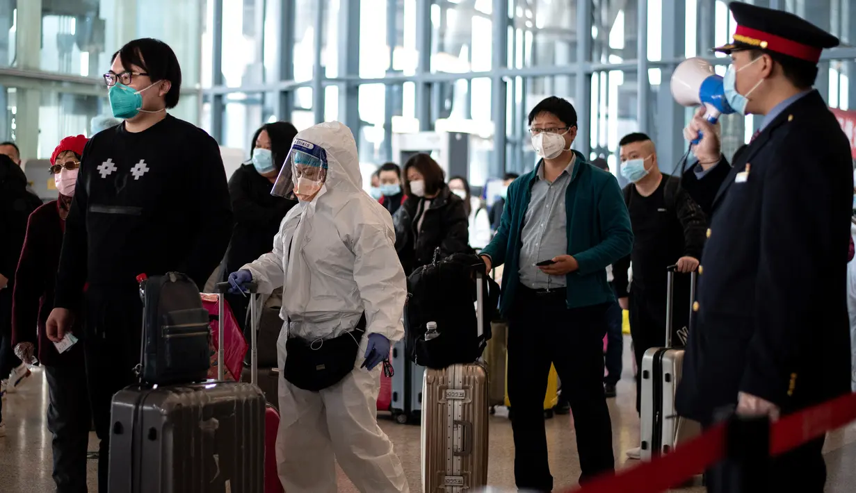 Para penumpang antre untuk menaiki kereta api menuju Beijing di stasiun kereta Wuhan, provinsi Hubei, Rabu (15/4/2020). Usai status lockdown dicabut pada 8 April lalu, orang-orang yang sebelumnya berada di Wuhan perlahan mulai meninggalkan kota, salah satu tujuannya adalah Beijing.  (NOEL CELIS/AFP)