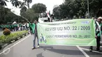 Massa dari pengemudi ojek online membentangkan spanduk sambil bergerak menuju Istana Negara, Jakarta, Senin (15/5). Mereka menuntut agar pemerintah segera merevisi UU No 22 Tahun 2009 tentang Lalu Lintas dan Angkutan Jalan. (Liputan6.com/Faizal Fanani)