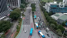 Foto aerial kendaraan melintas di Jalan Jenderal Sudirman, Jakarta, Selasa (24/3/2020). Sejumlah ruas jalan utama ibu kota lebih lengang dibandingkan hari biasa karena sebagian perusahaan telah menerapkan bekerja dari rumah guna menekan penyebaran COVID-19. (Liputan6.com/Faizal Fanani)
