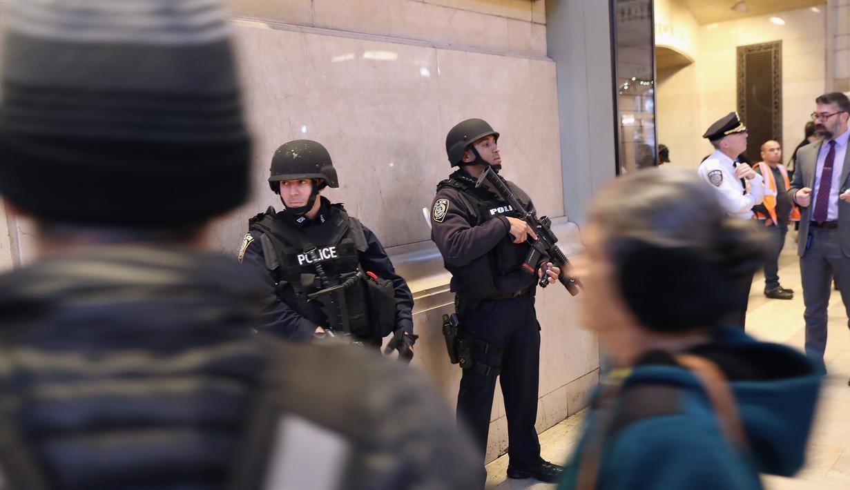 Polisi bersenjata lengkap berjaga di terminal Grand Central, New York City, pasca teror bom pipa, Senin (11/12). Imigran asal Bangladesh, Akayed Ullah (27), menjadi tersangka pelaku ledakan. (JOHN MOORE / GETTY IMAGES NORTH AMERICA / AFP)