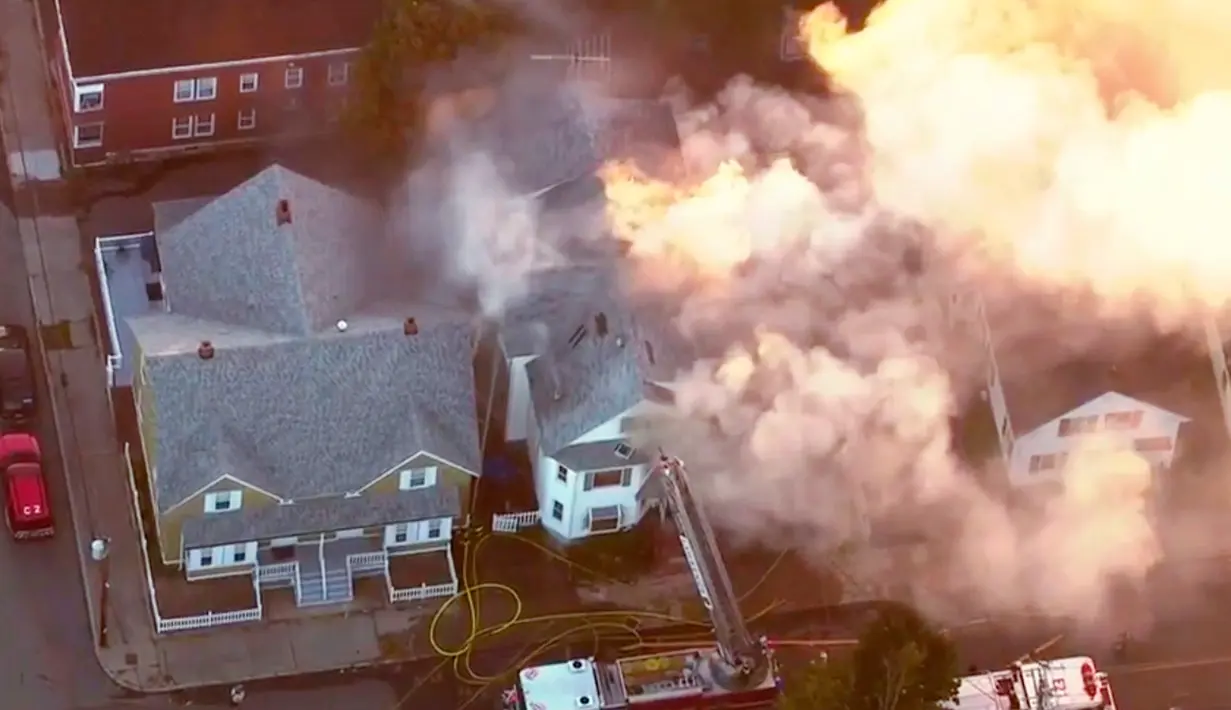 Petugas pemadam kebakaran berusaha menjinakkan api yang melalap rumah di Lawrance, dekat Boston, AS, Kamis (13/9). Rentetan ledakan dan kebakaran di tiga komunitas utara Boston itu juga menyebabkan lalu lintas di lingkungan sana padat. (WCVB via AP)