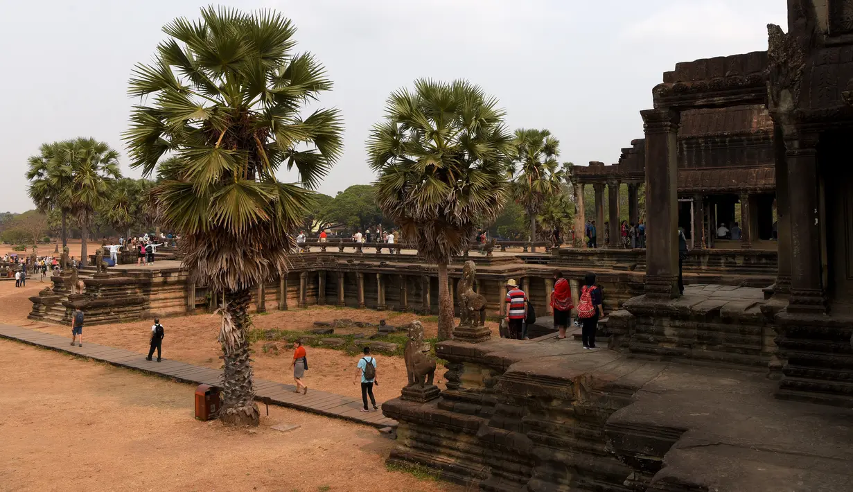 Turis mengunjungi candi Angkor Wat di provinsi Siem Reap pada 16 Maret 2019. Angkor Wat memegang peranan penting bagi perekonomian Kamboja karena merupakan destinasi dari 50 % turis yang tiba di Kamboja. (TANG CHHIN Sothy / AFP)