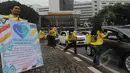 Aksi damai tersebut dengan membagikan bunga dan brosur mengenai kanker kepada pengendara yang lewat di Jalan Bundaran Tugu Tani dan Bundaran Senayan, Jakarta, Rabu (4/2/2015). (Liputan6.com/Herman Zakharia)
