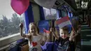 Warga negara asing mengibarkan bendera merah putih di Stasiun Gambir, Jakarta, Kamis (1/6). Dalam rangka memperingati HUT Pancasila PT KAI Daop 1 memberikan pin dan bendera merah putih kepada penumpang kereta api. (Liputan6.com/Faizal Fanani)