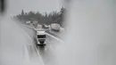 Truk melaju di jalan raya saat hujan salju, dekat kota Unec, Slovenia, pada Senin (23/1/2023). Hujan salju lebat dan angin kencang menghambat lalu lintas dan menyebabkan pemadaman listrik di seluruh Slovenia. (Jure Makovec / AFP)