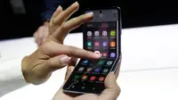 Seorang pekerja Samsung mendemonstrasi Galaxy Z Flip pada acara Unpacked 2020 di San Francisco, Selasa (11/2/2020). Menjadi perangkat kedua dengan layar lipat karyanya, Samsung menghadirkan perbedaan desain pada Galaxy Z Flip jika dibandingkan ponsel generasi pertama, Galaxy Fold. (AP/Jeff Chiu)