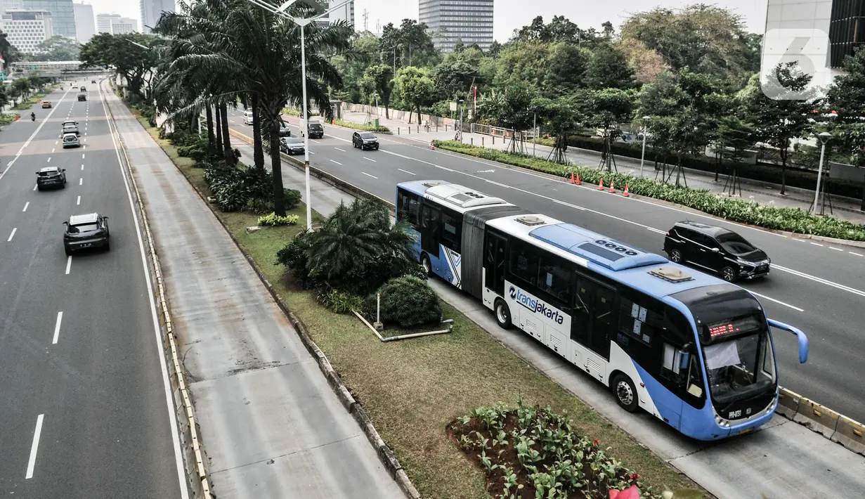 Bus gandeng Transjakarta melintas di Jalan Sudirman, Jakarta, Minggu (2/8/2020). PT Transjakarta akan menambah armada sebanyak 155 mengantisipasi lonjakan pelanggan saat diberlakukan kebijakan ganjil genap di sejumlah ruas jalan utama Jakarta pada Senin, 3 Agustus 2020. (merdeka.com/Iqbal Nugroho)