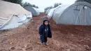 Seorang bocah laki-laki berdiri di jalanan berlumpur di kamp pengungsi Bab Al-Salam, dekat perbatasan Suriah-Turki, Provinsi Aleppo Utara, Senin (26/12). Di sini tercatat sekitar ribuan warga yang telah lama hidup di tenda. (REUTERS/Khalil Ashawi)