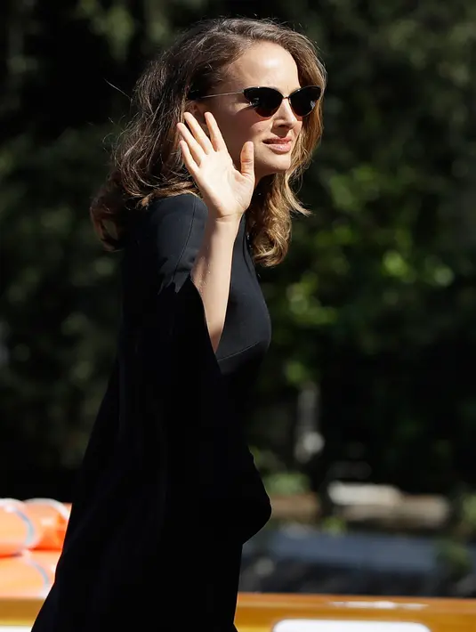 Aktris Natalie Portman menyapa awak media saat tiba di dermaga Excelsior Hotel selama Festival Film Venice ke-75 di Venice Lido, Italia, (4/9). Natalie Portman tampil cantik menggenakan dress hitam. (AP Photo/Kirsty Wigglesworth)
