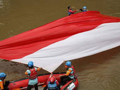 Sejumlah relawan membentangkan bendera Merah Putih di aliran kali
Ciliwung di kawasan Sudirman, Jakarta, Minggu (22/8/2021). Pembentangan atau pengibaran bendera Merah Putih tersebut dilaksanakan untuk memperingati HUT ke-76 RI. (Liputan6.com/Faizal Fanani)