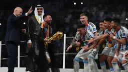 Setelah pemberian trofi Piala Dunia oleh Presiden FIFA, Lonel Messi lalu menghampiri rekan-rekannya yang sudah menantikan trofi tersebut di atas panggung. (AFP/Franck Fife)
